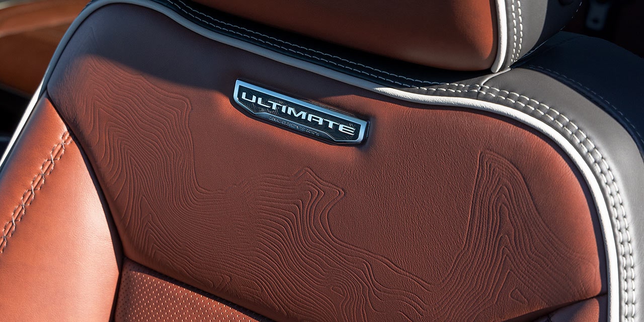 Close-up of the Premium Materials and Ultimate Trim Nameplate on the 2026 GMC Sierra HD Heavy Duty Truck Seat