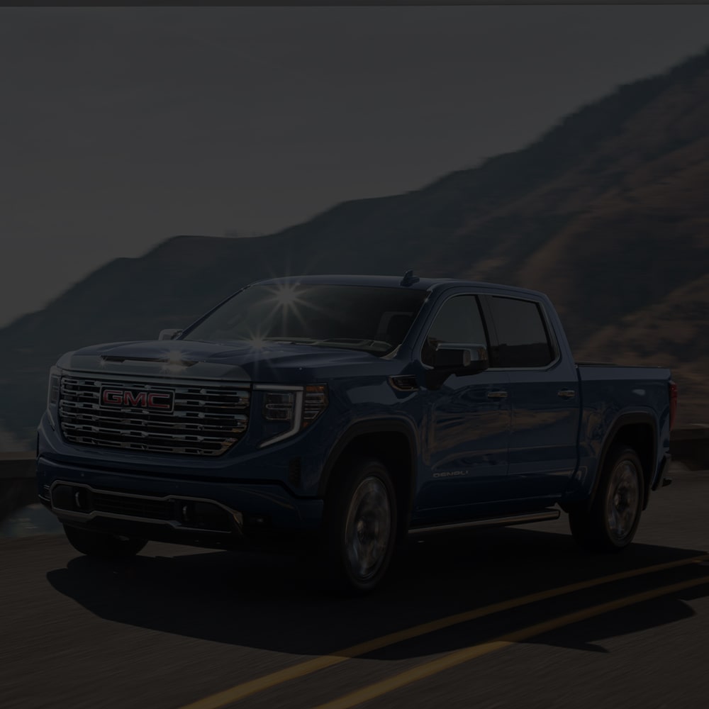 The 2026 GMC Sierra 1500 Pickup Truck Driving Down the Coast Line as the Sun Shines off of the Windshield