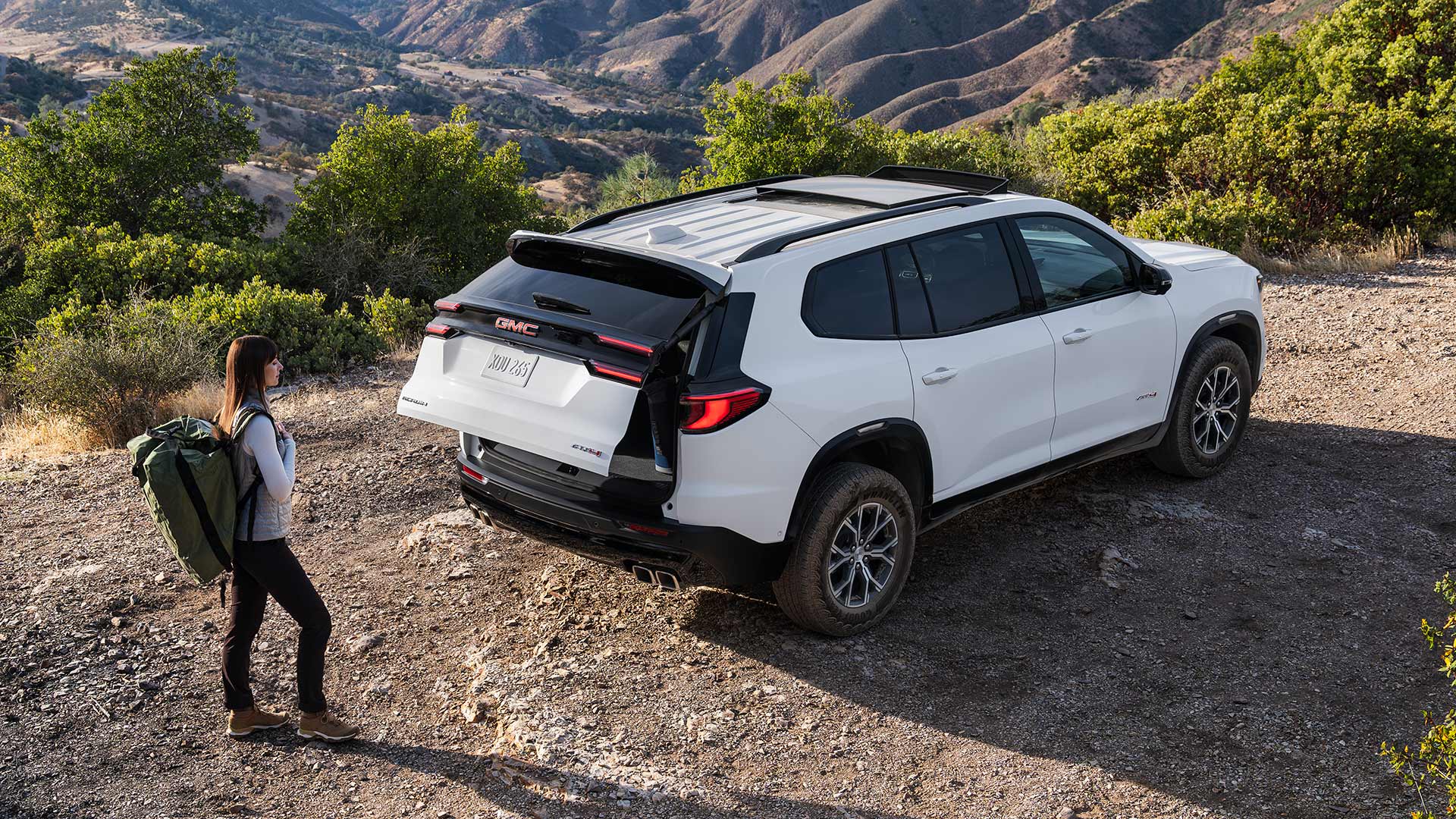 A Woman Approaching the Rear of A GMC Acadia to Use the Power Liftgate