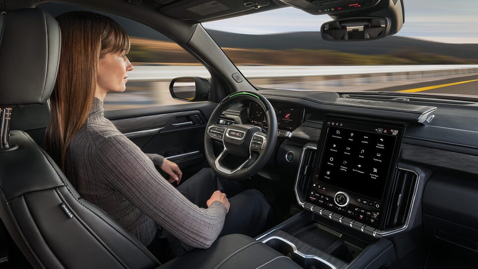 Profile View of a Woman Using Super Cruise Hands-Free Driving in her GMC Acadia SUV