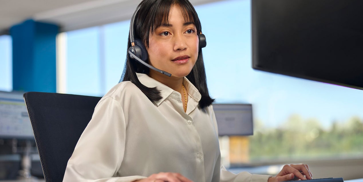 An OnStar Advisor Sitting at her Computer with a Headset on