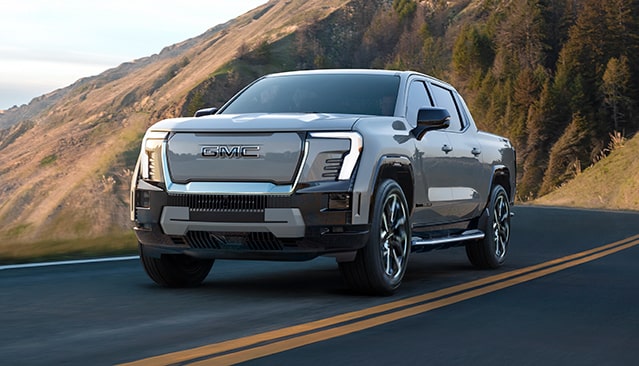 The GMC Sierra EV Driving Down a Winding Mountain Road Along the Coast